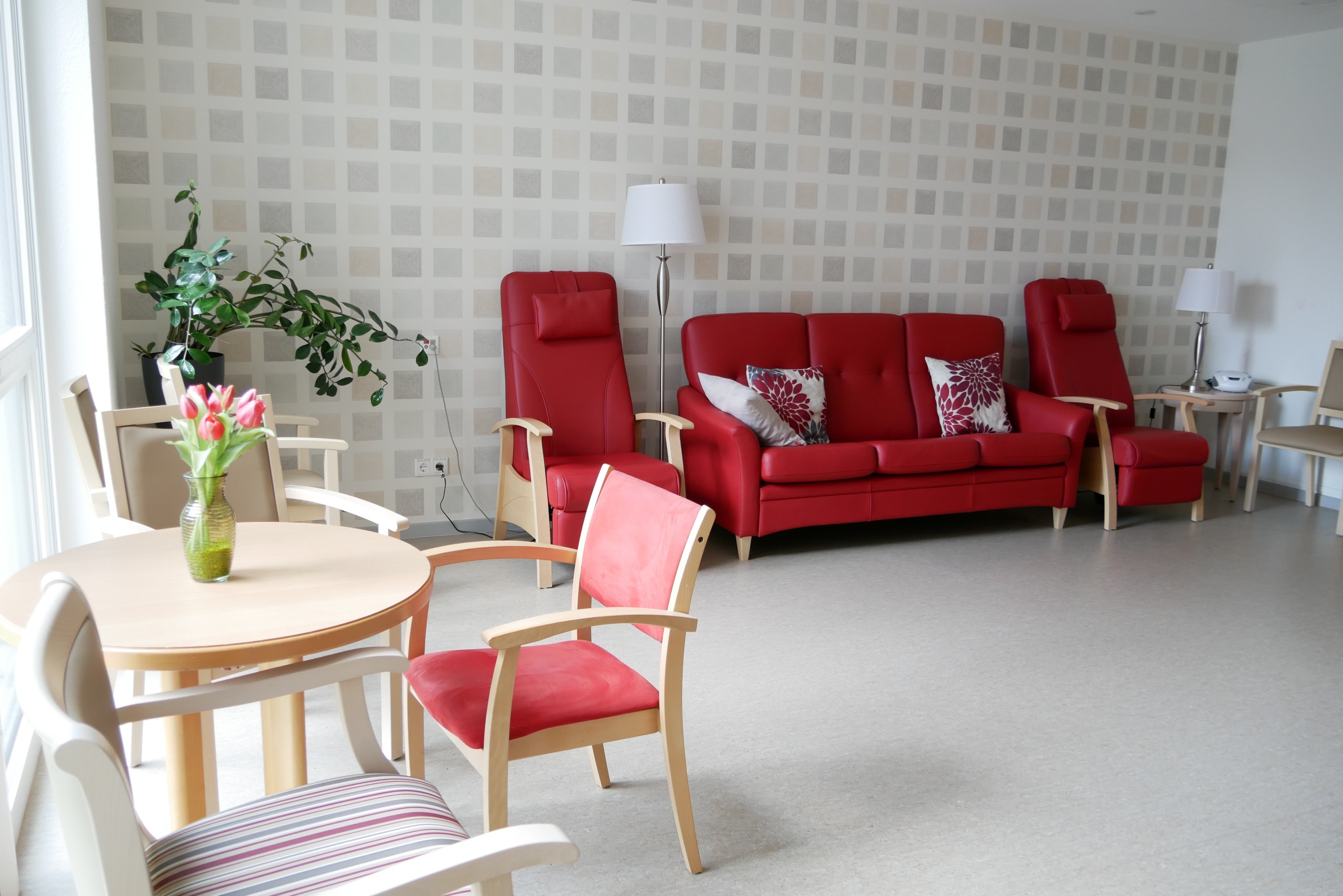 Ein Wohnzimmer mit einem roten Sofa und einem Tisch mit Stühlen