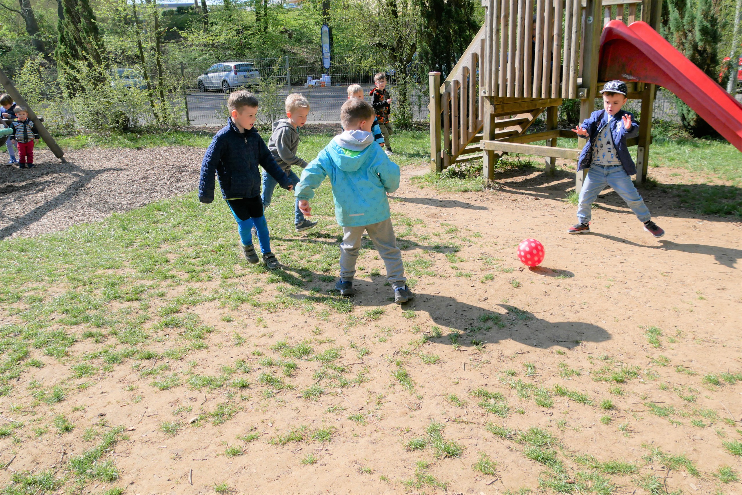 Kinder spielen auf dem Außengelände Fußball