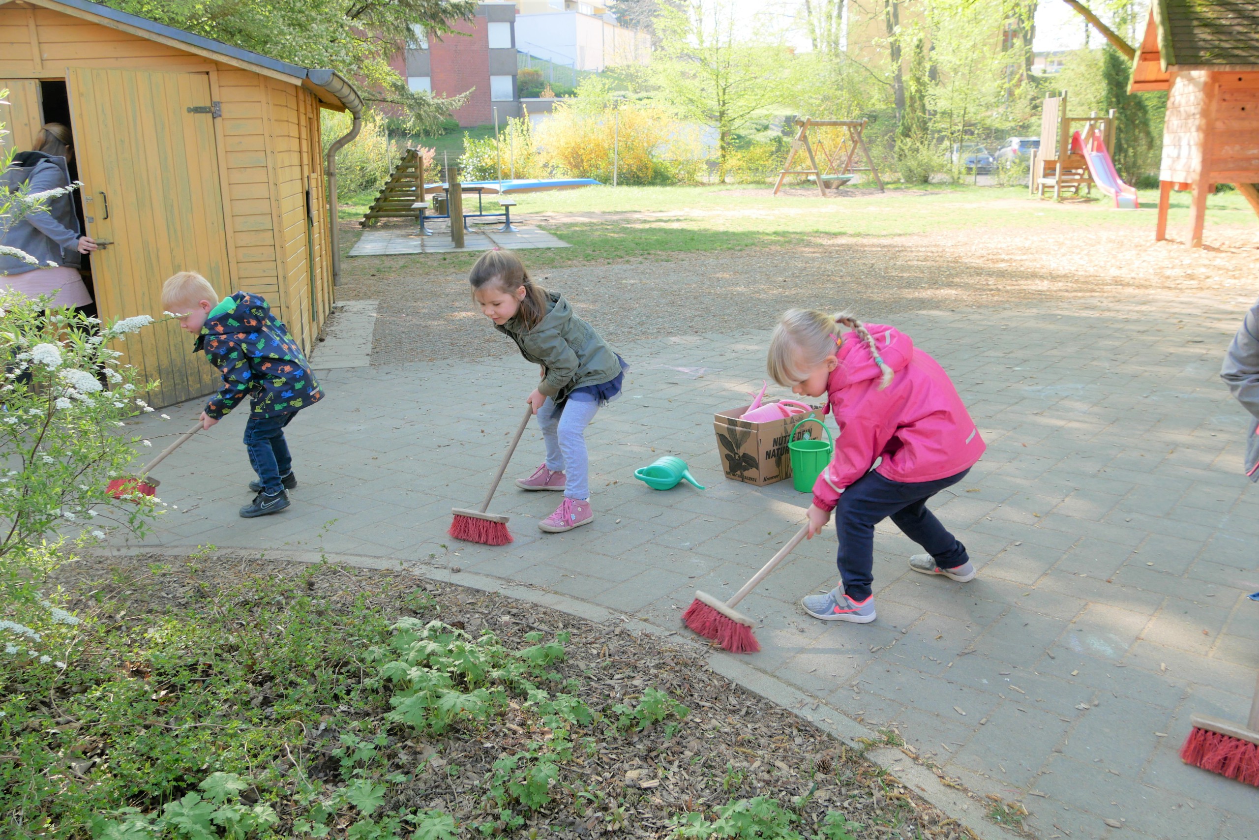 Kinder fegen den Hof