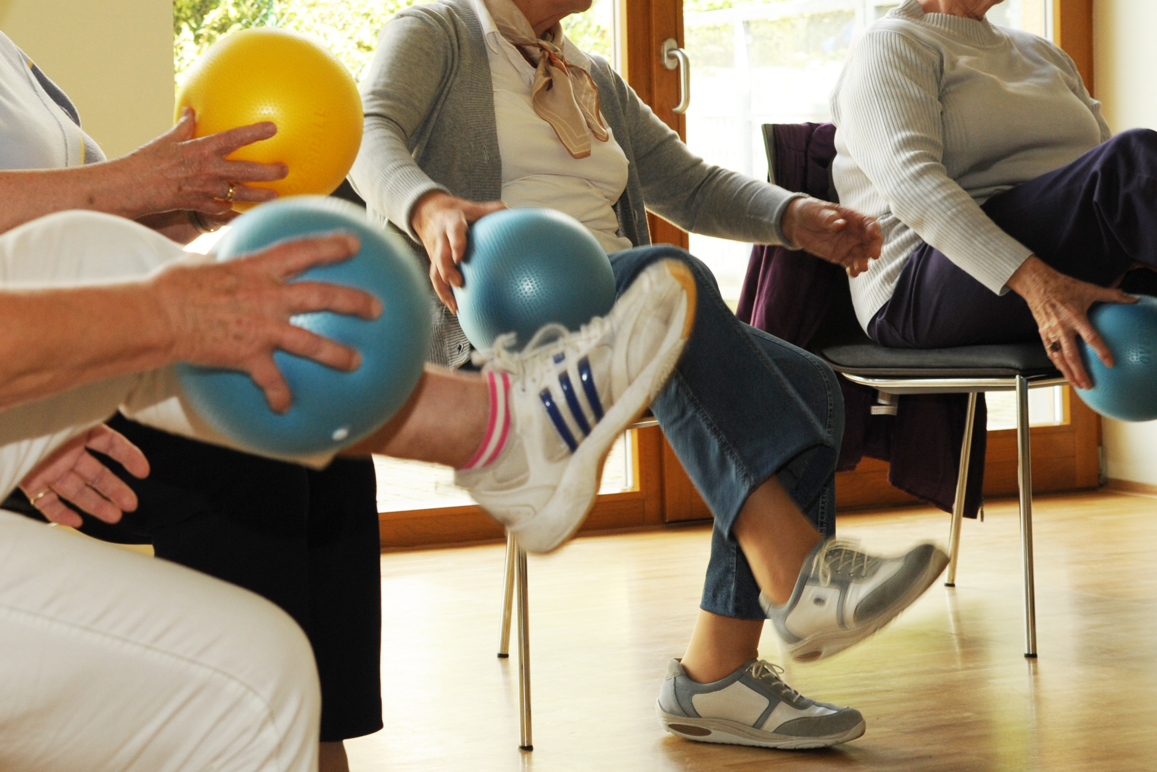 Mehrere Personen in einem Bewegungsangebot mit Ball