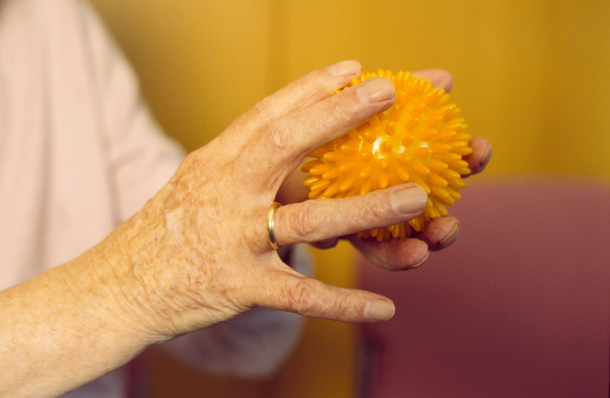 Hände einer älteren Person hatlten einen Massageball