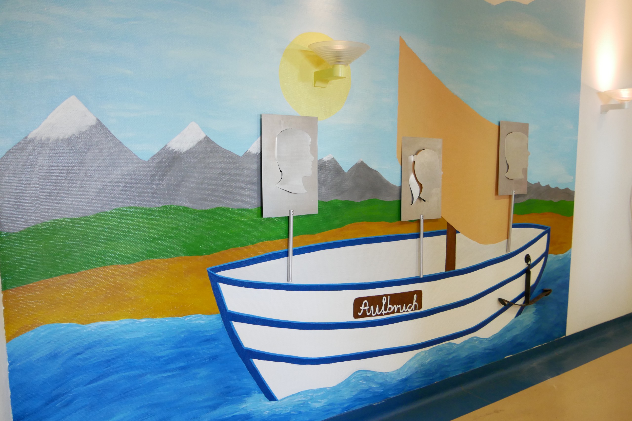 Eine Wand mit einem aufgemalten bunten Segelboot mit der Aufschrift Aufbruch