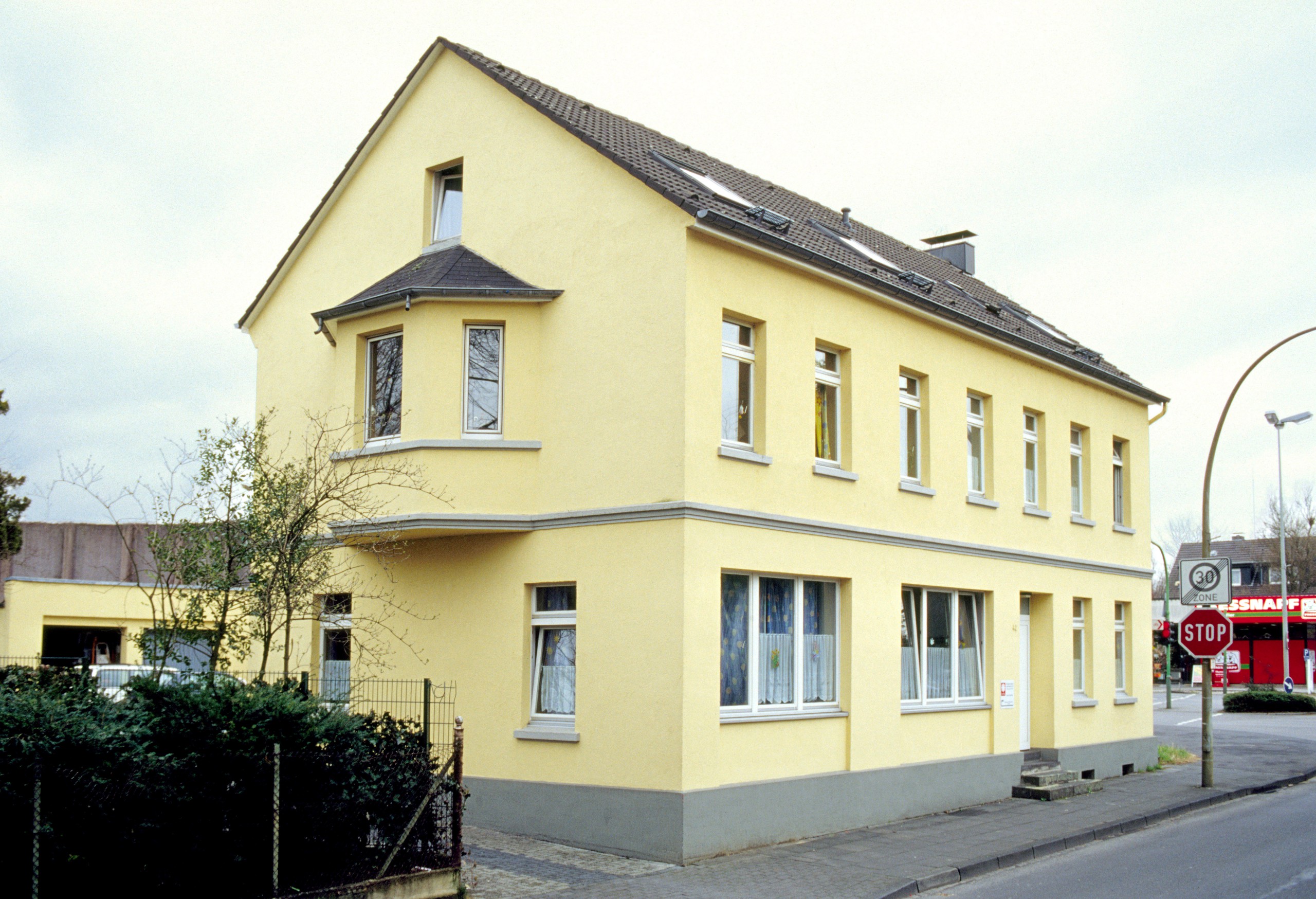 Zweistöckiges gelbes Gebäude mit kleinem Erker