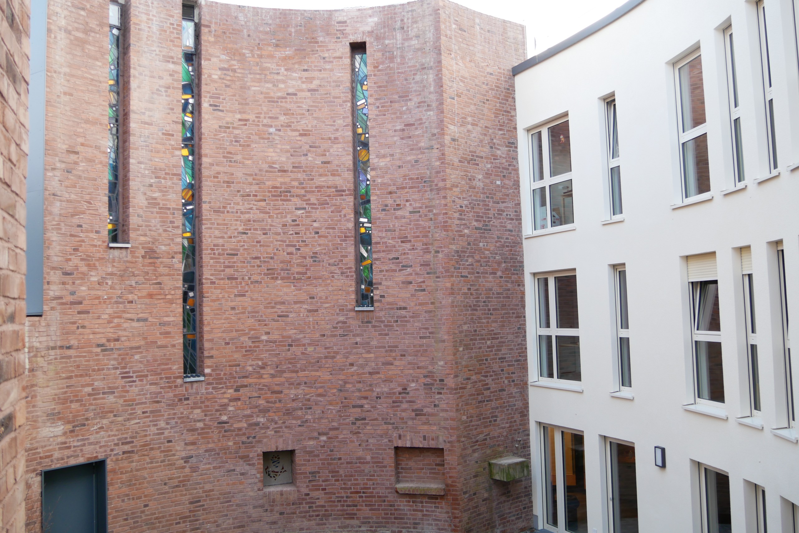 Gebäude mit Backsteinmauer und weißer Fassade